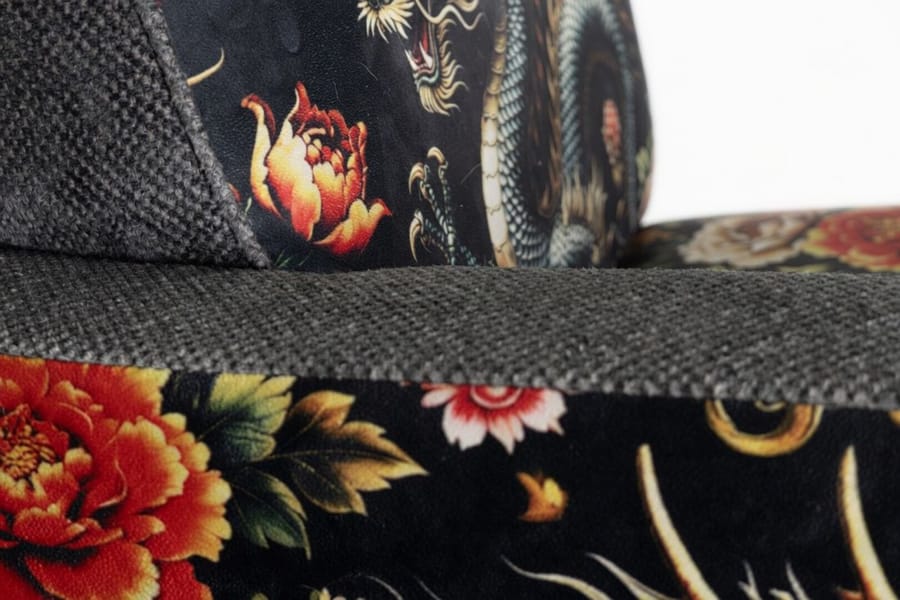 Detalhe da costura entre bouclé cinza e veludo vermelho da poltrona RYUJIN